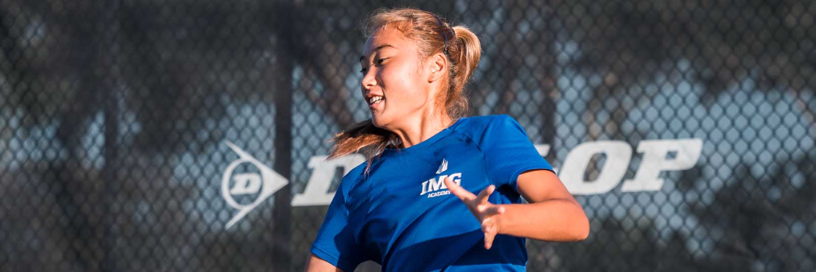 Female tennis player on court hitting ball