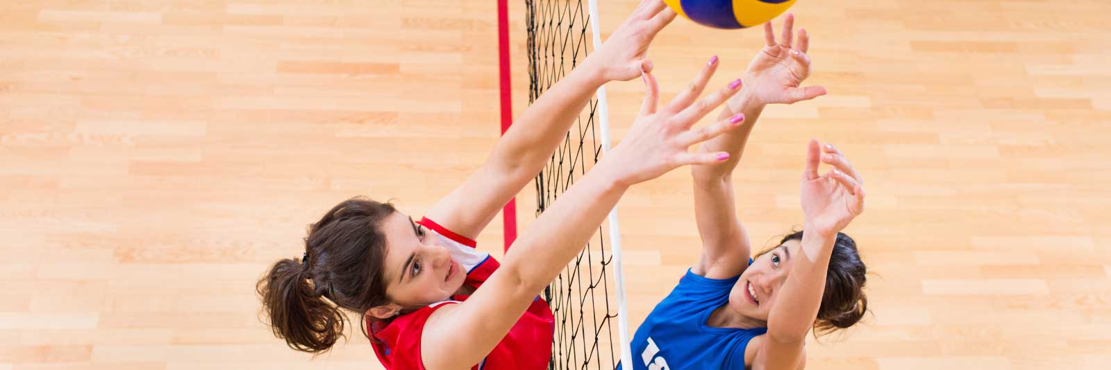 Women's volleyball play at the net