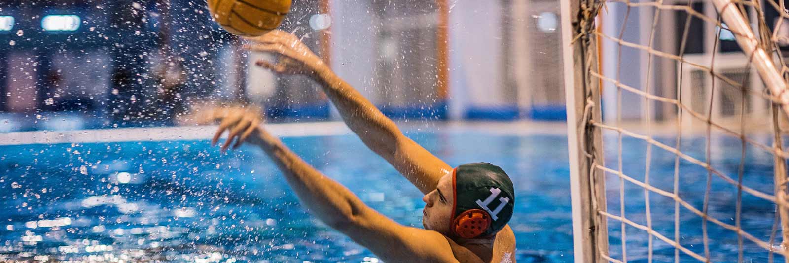 men's water polo goalkeeper blocking a ball