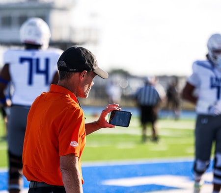 College coach using his phone